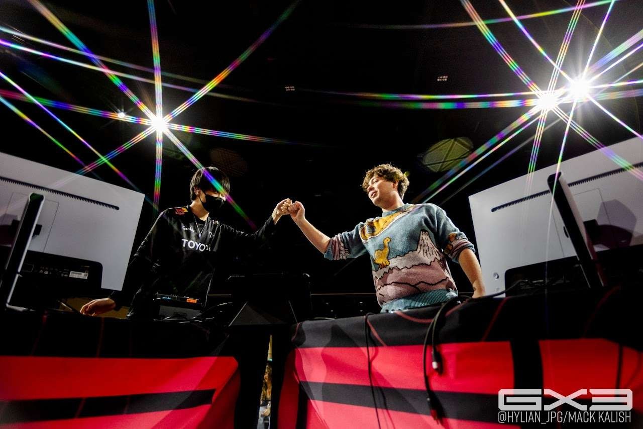Two competitors fist-bump across the stage at GENESIS X3